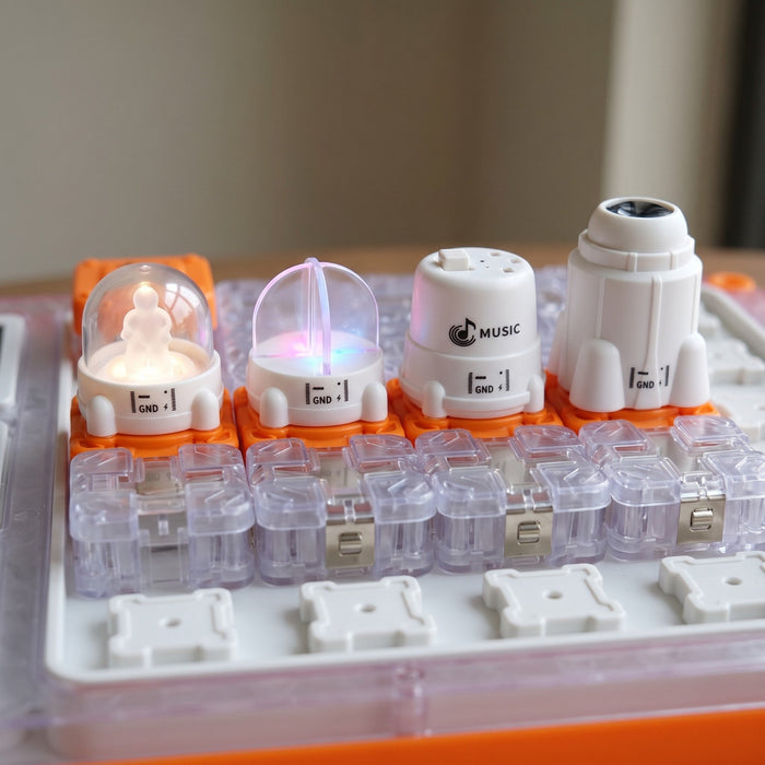 Close-up of four pieces on the board: a light with a glowing figure, a glowing clear dome, a music block and a rocket