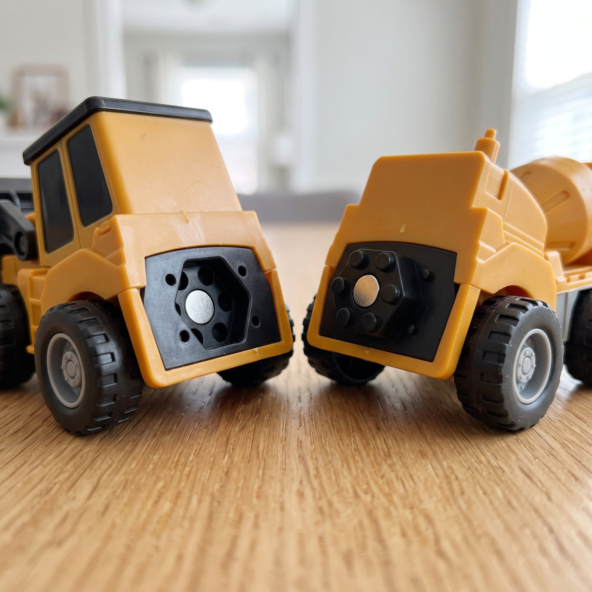 Close-up of two vehicles end to end, showing the round magnet inside the black hexagon connector on each one