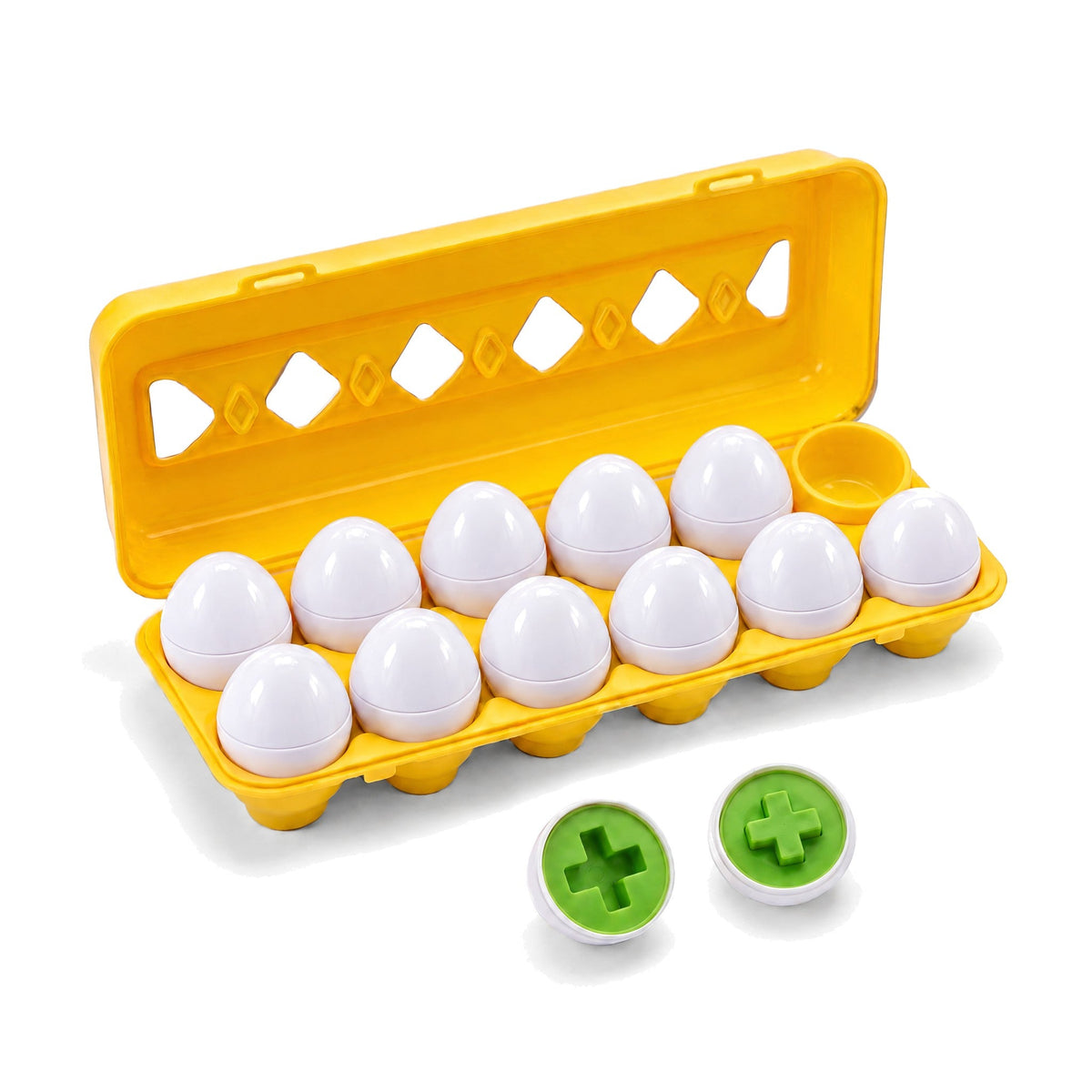 Groovd Geometric Eggs: a yellow carton of white plastic eggs, with one egg split open to show matching green cross shapes