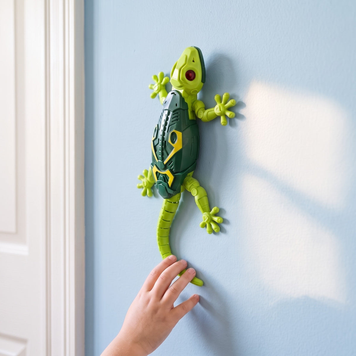 A child's hand reaches up to the lizard as it climbs a blue wall next to a door