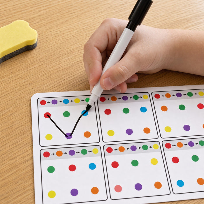 A child's hand joins the red, purple and blue dots in order with a black marker, with the yellow eraser nearby.